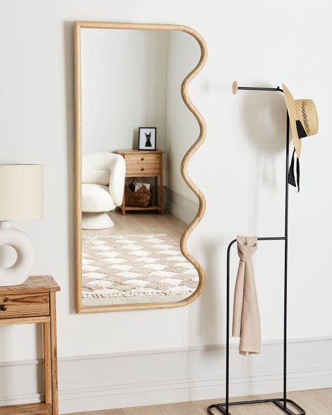 Dekorativer Spiegel mit Holzrahmen und Garderobenständer mit Hut und Schal