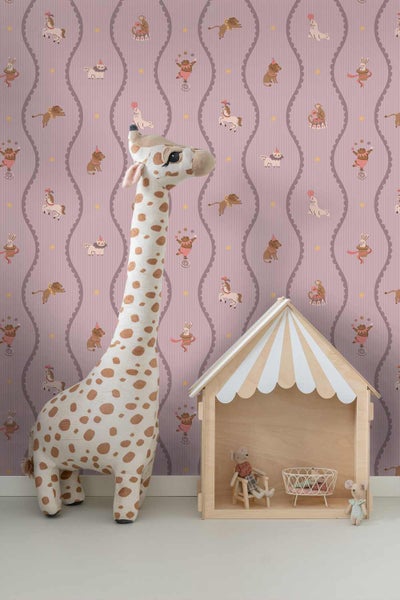 Kinderzimmer mit Vliestapete mit Zirkusmotiven, einer großen Plüschgiraffe und einem hölzernen Spielhaus.