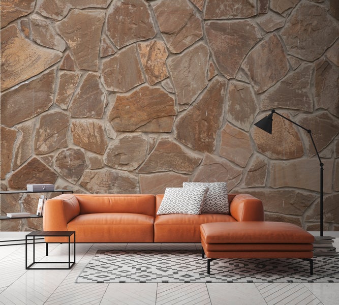 Wohnzimmer mit Ledersofa, Couchtisch, Bücherregal und Natursteinwand