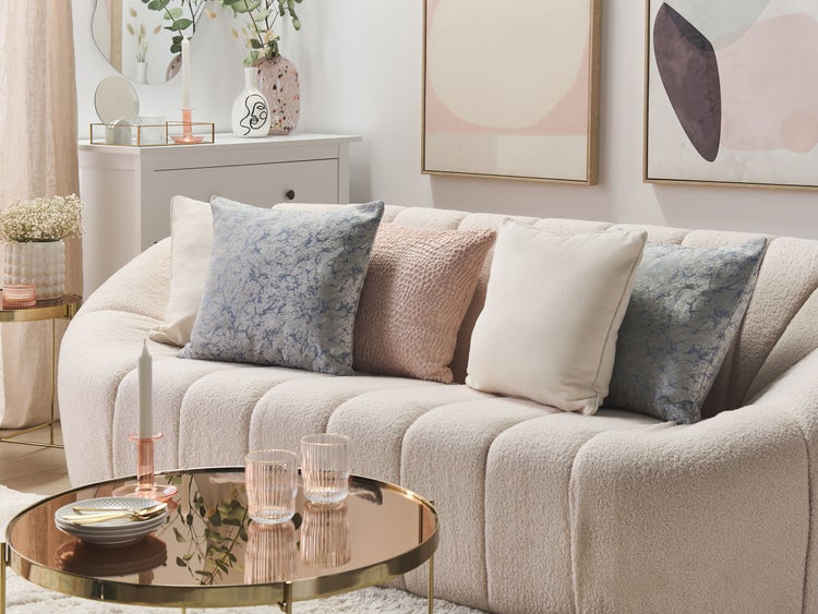 Wohnzimmer-Szene mit Sofa, Kissen und Dekorationen auf Beistelltisch