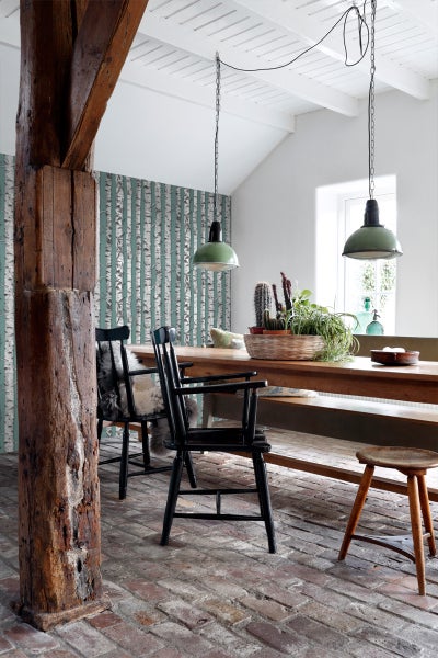 Esszimmer mit Holztisch, Stühlen, Pendelleuchten und Birkenmuster-Tapete