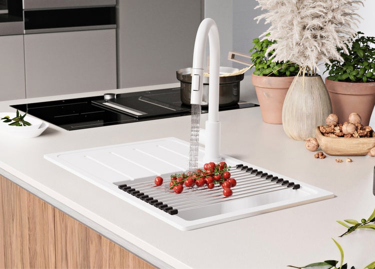 Küchenszene mit Spüle, Armatur und Abtropfgestell mit Tomaten