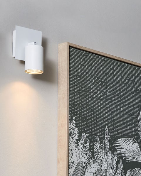 Weiße moderne Wandleuchte mit zylindrischem Strahler und quadratischer Halterung an einer Wand.