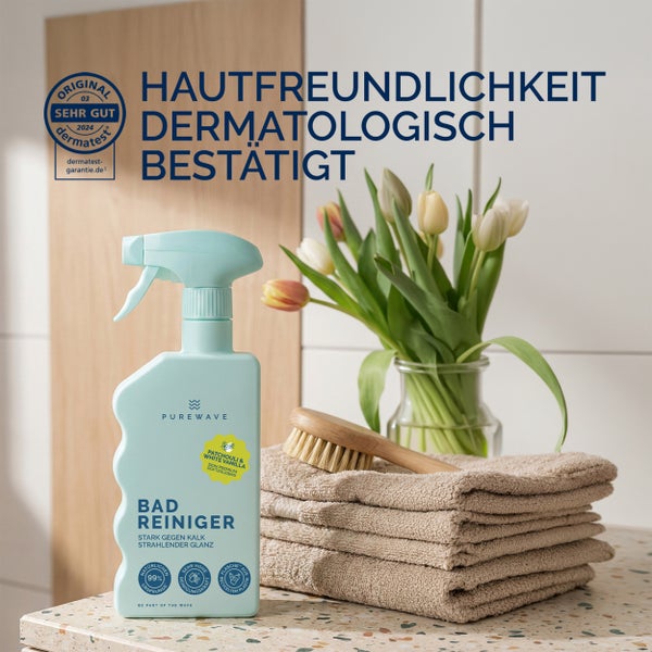 Purewave Badreiniger Sprühflasche neben Handtüchern und Blumen