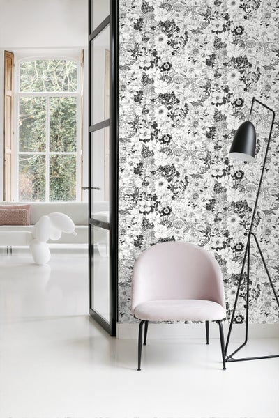 Heller Raum mit floraler Tapete, Sessel und Stehlampe