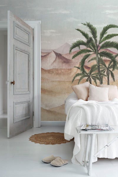 Schlafzimmer mit Wüsten-Tapete, Bett, Tisch und geöffneter Tür