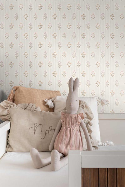 Vliestapete mit kleinem Blumenmuster und feinen Streifen im Kinderzimmer mit Bett, Kissen und Kuscheltier-Hase.