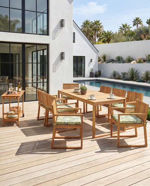 Modernes Gartenmöbel-Set aus Holz mit rechteckigem Tisch, Stühlen mit Sitzkissen und Servierwagen auf einer hellen Terrasse am Pool.