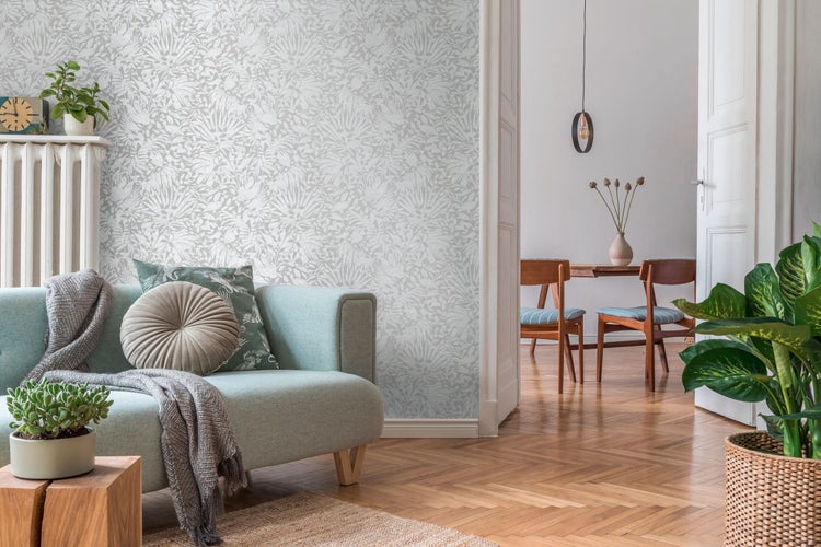 Wohnzimmer mit gemusterter Tapete, Sofa und Holzboden