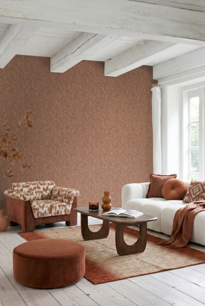 Helles Wohnzimmer mit gemusterter Vliestapete, weißer Balkendecke, modernem Sofa, gemustertem Sessel, Holz-Couchtisch und passenden Heimtextilien.
