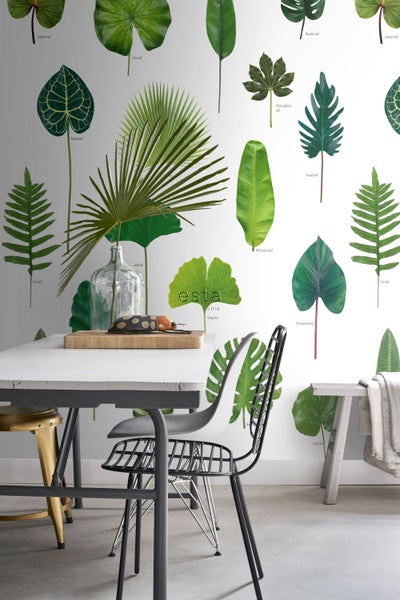 Dekoratives Interieur mit Tisch, Stühlen und einer Wandtapete mit verschiedenen Blättern