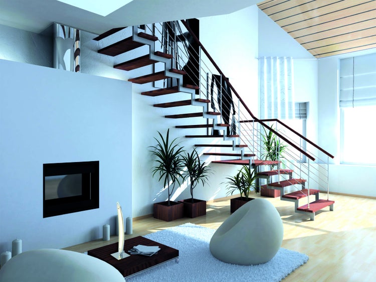 Heller Wohnraum mit Treppe, Sesseln, Teppich und Zimmerpflanzen.