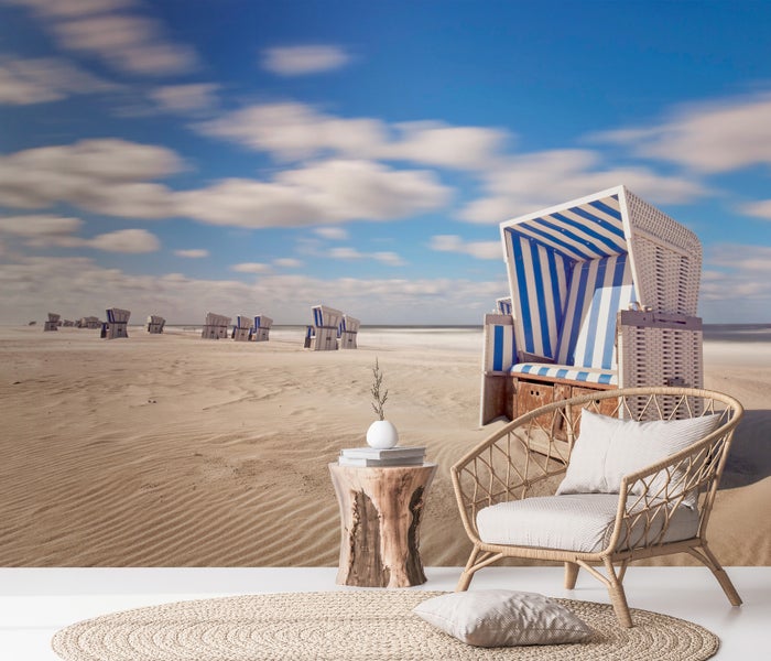 Raumszene mit Strandkorb-Motiv im Hintergrund, Korbsessel und Beistelltisch mit Dekoration