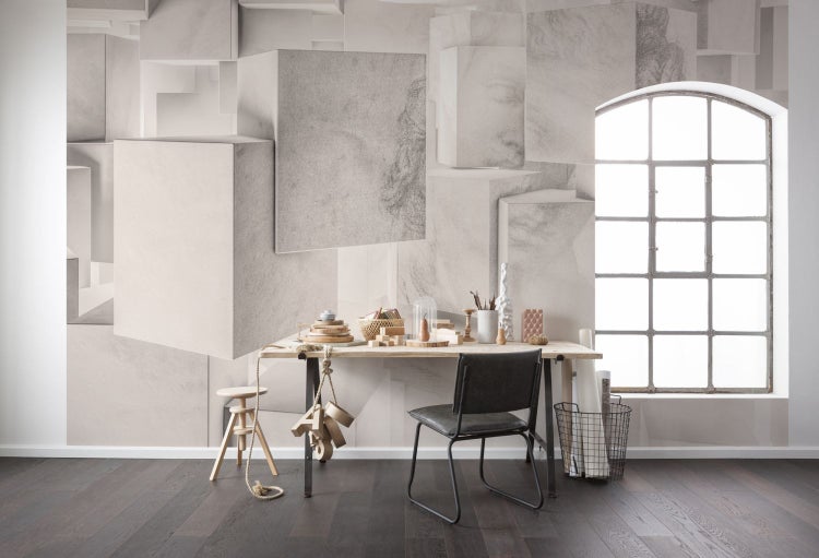 Ein Arbeitszimmer mit einem Schreibtisch, einem Stuhl und einer Wand mit geometrischem Muster.