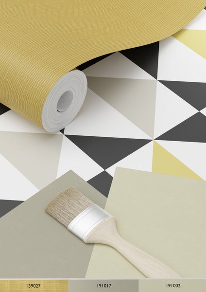 Szene mit einer Tapetenrolle, einem Pinsel und Mustern in geometrischem Design.