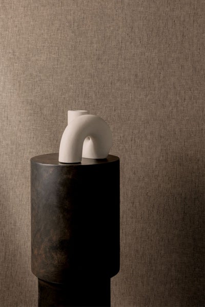 Dekoratives Zimmer mit einer braunen Blumentapete, einem rosa Schrank und Accessoires wie einem Hut, einem Kleid und Stiefeln.