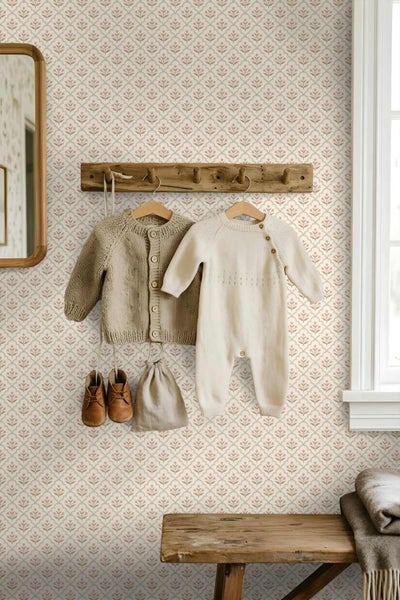 Vliestapete mit floralem Muster in einem hellen Zimmer mit Holzgarderobe, Babykleidung und einer Holzbank.