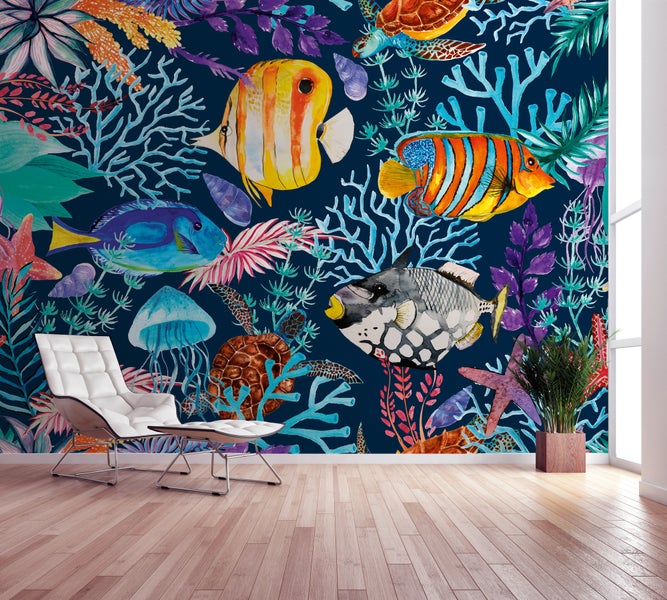 Fototapete mit Unterwasser-Motiv, Fischen und Korallen im Aquarell-Stil in einem modernen, hellen Raum mit weißem Sessel.