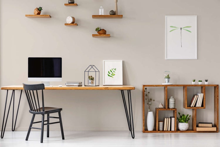 Modernes Heimbüro mit Holztisch auf Haarnadelbeinen, schwarzem Stuhl, dekorativen Wandregalen und einem offenen Holzregal.