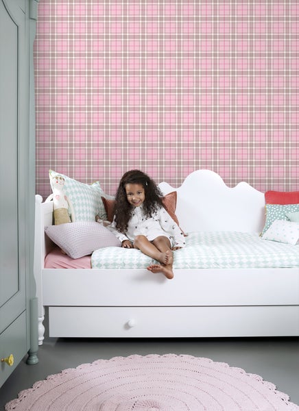 Ein Kinderzimmer mit karierter Tapete, einem weißen Bett und einem runden Teppich.