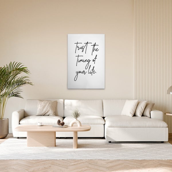 Dekoratives Poster mit dem Schriftzug Vertraue auf das Timing deines Lebens in einem Wohnzimmer