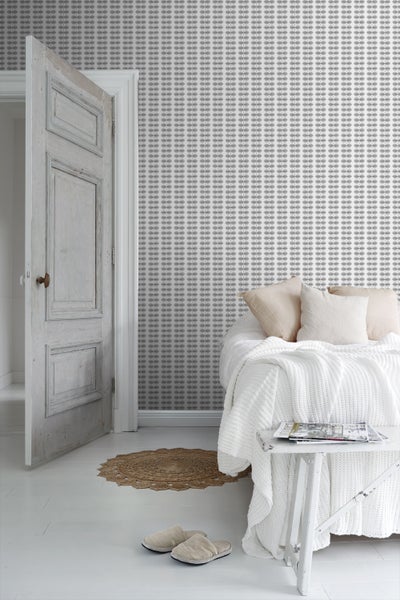 Helles Schlafzimmer mit gemusterter Tapete, Bett und offenstehender Tür