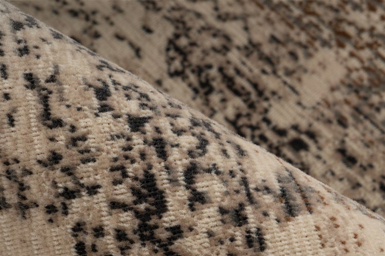 Nahaufnahme eines beige-grauen Teppichs mit Vintage-Muster und gewebter Textur.