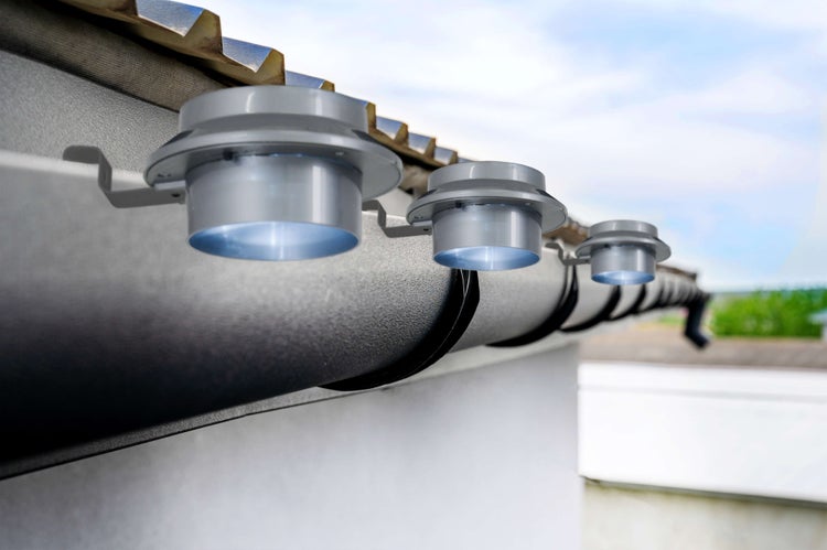 Reihe von Dachrinnenleuchten an einer Hausdachrinne