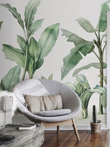 Wohnzimmer mit Pflanzen Tapete, Sessel, Kissen und Holzfußboden