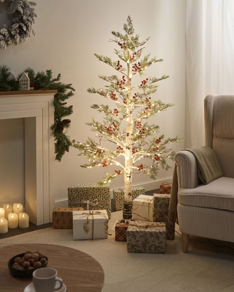 Festliche Wohnzimmerdekoration mit geschmücktem Baum, Geschenken und Kamin