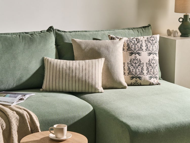 Grünes Sofa mit Kissen in verschiedenen Designs