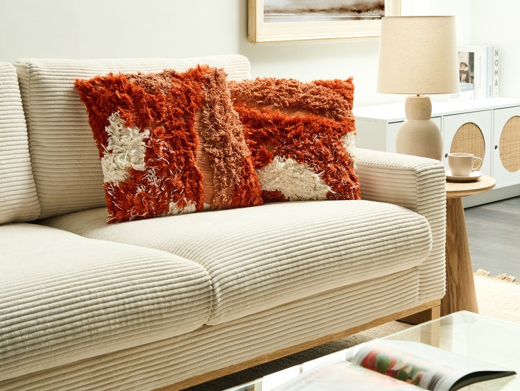 Cordsofa mit zwei dekorativen Kissen mit Fransenmuster