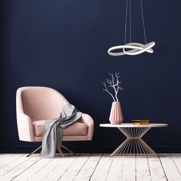 Dekorative Wohnzimmerszene mit Sessel, Tisch, Lampe und Accessoires für gemütliches Ambiente