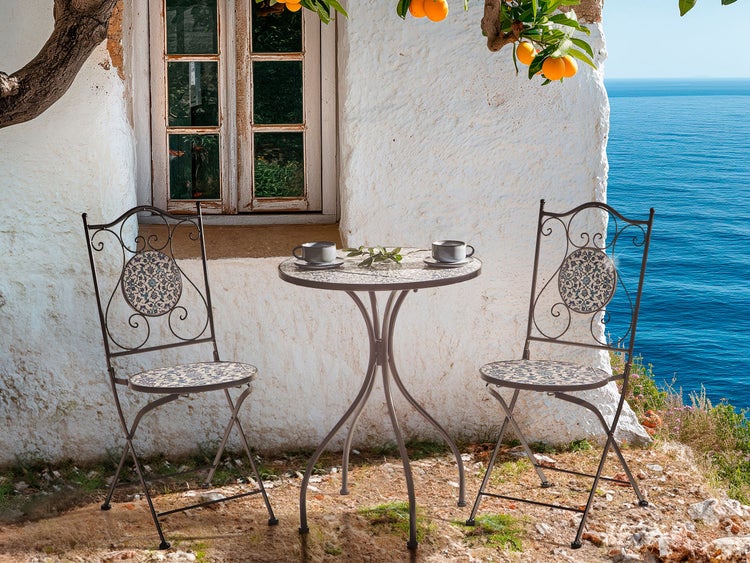 Gartensitzgruppe mit Tisch und zwei Stühlen vor einem Haus am Meer