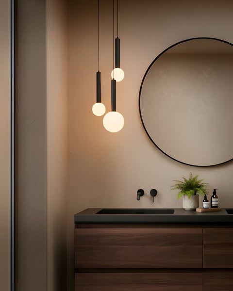 Modernes Badezimmer mit hölzernem Waschtisch, rundem Spiegel und Hängeleuchten