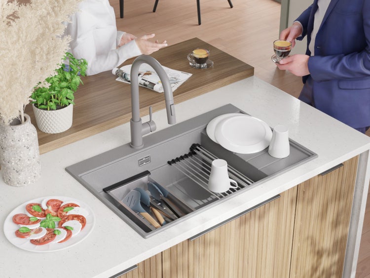 Küchenspüle mit Abtropfgestell, Armatur und Geschirr auf einer Küchentheke