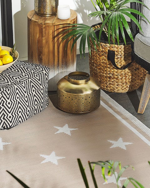 Beigefarbener flachgewebter Teppich mit weißen Sternen und Randstreifen.