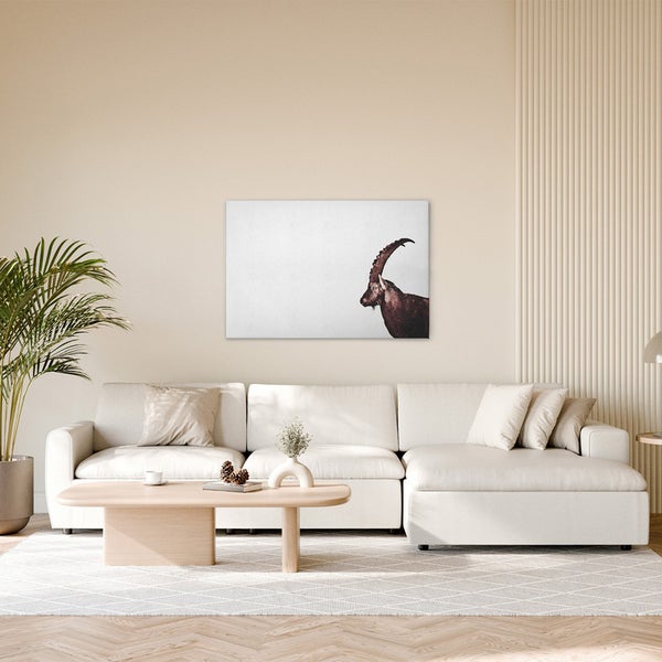 Wohnzimmer mit Sofa, Couchtisch und Wandbild eines Steinbocks