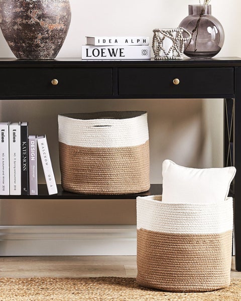 Dekorative Aufbewahrungskörbe auf einem Tisch mit Schubladen und dekorativen Elementen.