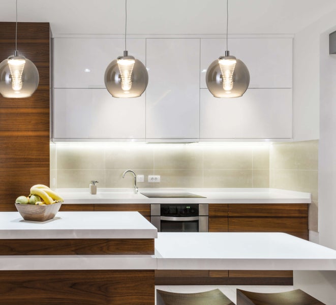 Moderne Küche mit Küchenschränken, Arbeitsplatte und Hängeleuchten