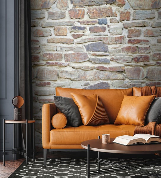 Wohnzimmer mit braunem Sofa, Kissen, Tisch und Steinwandtapete