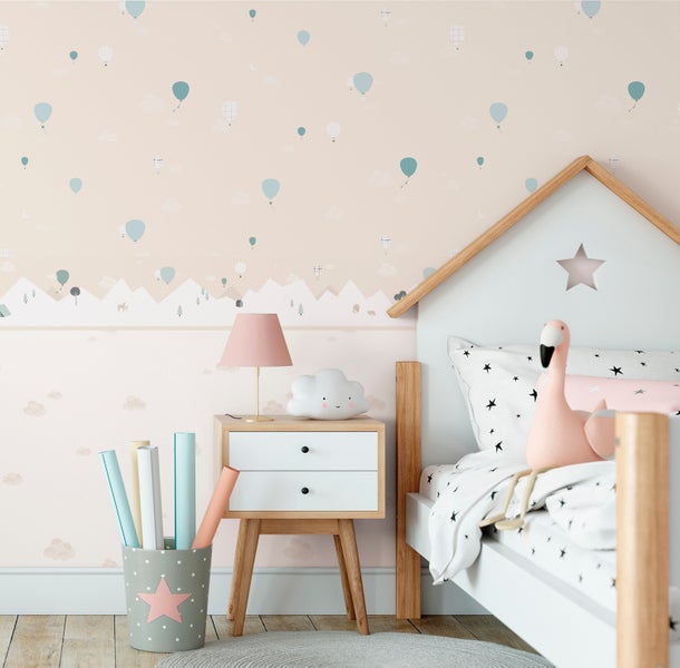 Kinderzimmer mit Bett im Hausdesign, Nachttisch, Lampe und Dekoration vor einer Tapete mit Heißluftballons