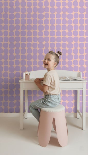 Vliestapete mit geometrischem Muster im hellen Kinderzimmer mit Schreibtisch und Hocker.