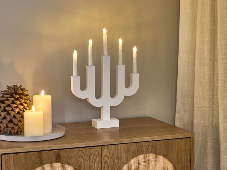 Dekorative LED-Lichterleuchte mit fünf Lichtern auf einem Holzschrank mit Dekorationsartikel.