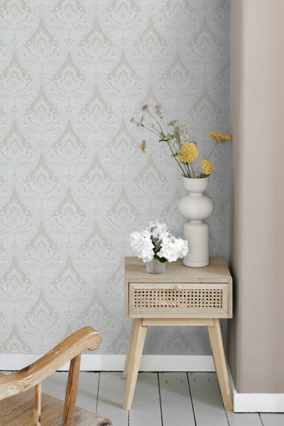 Wohnszene mit gemusterter Tapete, Beistelltisch mit Schublade und Blumenvasen