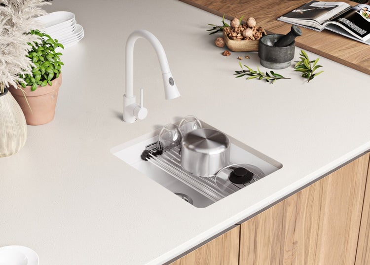 Küchenszene mit Spüle, Armatur und Abtropfgestell auf einer hellen Arbeitsplatte