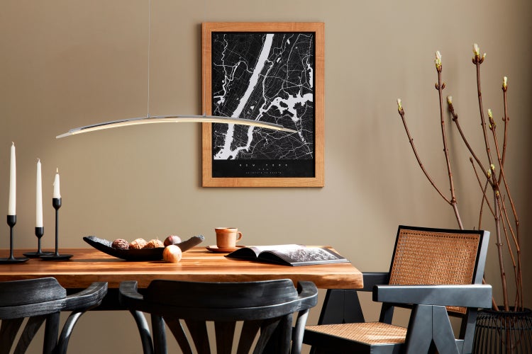 Ein Esszimmer mit einem Holztisch, Stühlen, einer Hängelampe und einer Wanddekoration