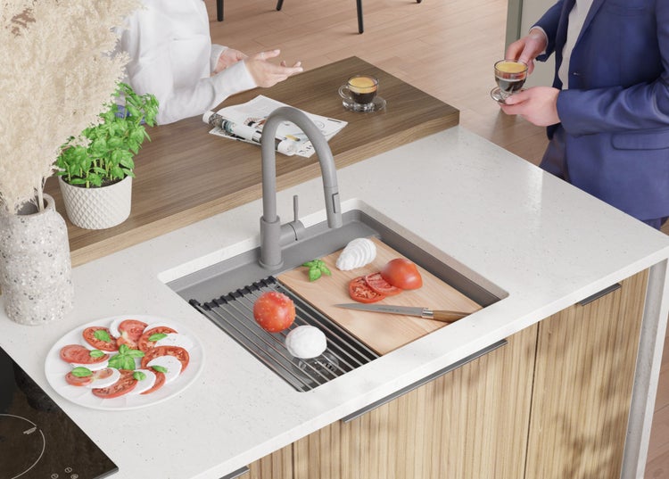 Küchenspüle mit Schneidebrett, Tomaten und Mozzarella auf einer Holzplatte