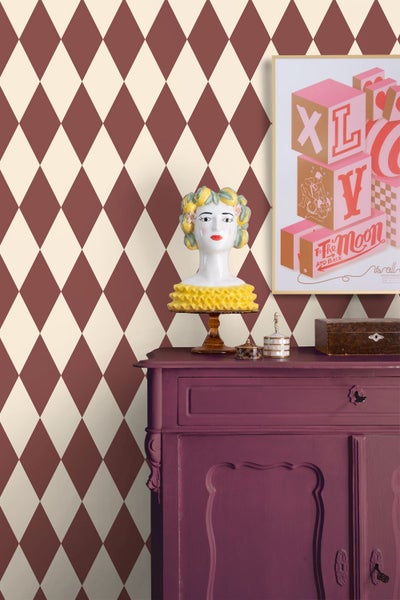 Wohnszene mit Tapete im Rautenmuster, Kommode und Dekoration