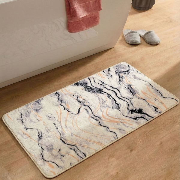 Badematte mit Marmor-Optik in einem hellen Badezimmer auf Holzboden vor einer weißen Badewanne.